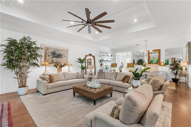 202 Strand Sq, Vero Beach, FL 32963 - living area with ceiling fan, a tray ceiling, wood finished floors, a chandelier, and wood ceiling