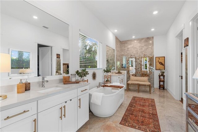 202 Strand Sq, Vero Beach, FL 32963 - bathroom featuring plenty of natural light, walk in shower, a soaking tub, recessed lighting, and vanity