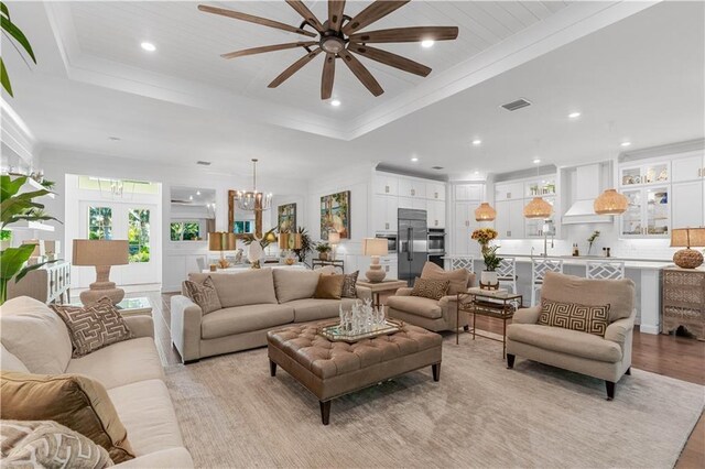 202 Strand Sq, Vero Beach, FL 32963 - living room featuring a ceiling fan, a chandelier, a raised ceiling, light wood finished floors, and recessed lighting
