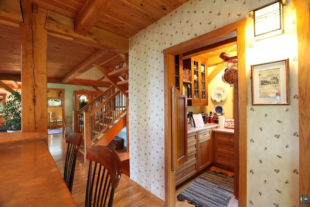 hallway with beam ceiling, light hardwood / wood-style floors, and wood ceiling