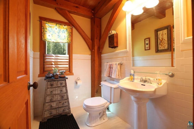 bathroom featuring backsplash, beamed ceiling, tile walls, and toilet