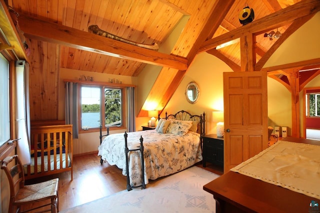 bedroom with wooden ceiling, lofted ceiling with beams, a water view, and hardwood / wood-style floors