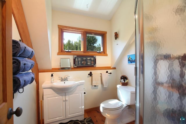 bathroom with hardwood / wood-style floors, vanity, toilet, and lofted ceiling