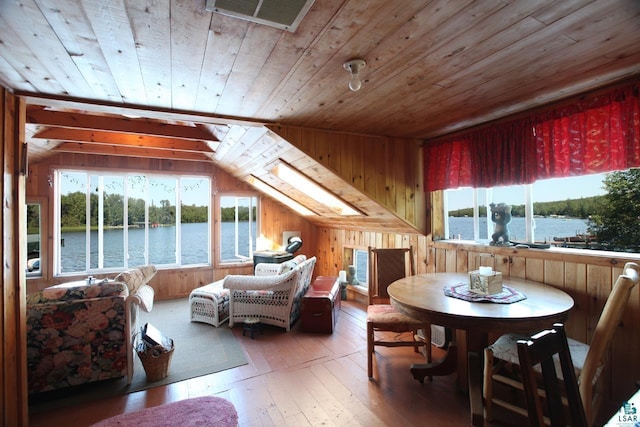 interior space featuring a water view, lofted ceiling with skylight, and wooden ceiling