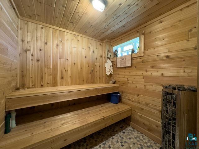 view of sauna / steam room featuring wood ceiling, tile flooring, and wooden walls