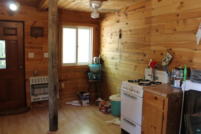 kitchen with white gas range oven, wood ceiling, a healthy amount of sunlight, and light wood-type flooring