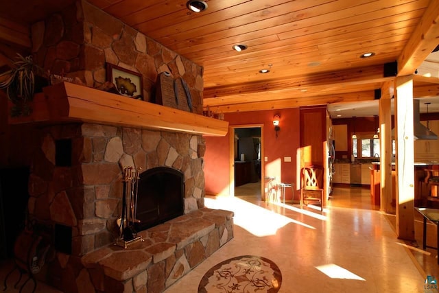 living room with sink, a stone fireplace, and wooden ceiling