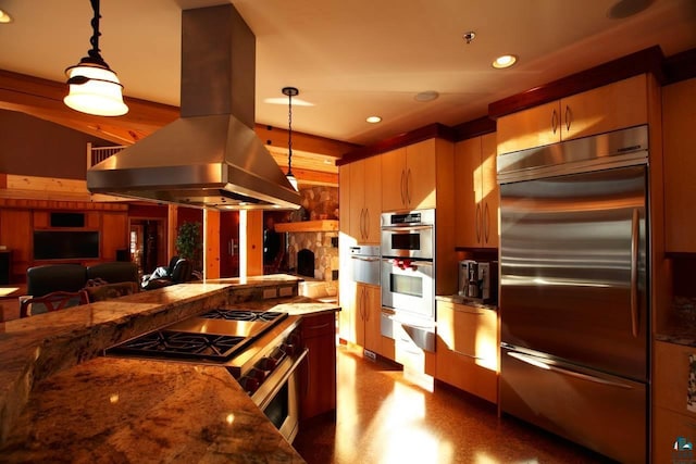 kitchen with stainless steel appliances, dark stone counters, decorative light fixtures, and island range hood