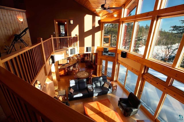 sunroom / solarium with ceiling fan, wooden ceiling, and vaulted ceiling with beams