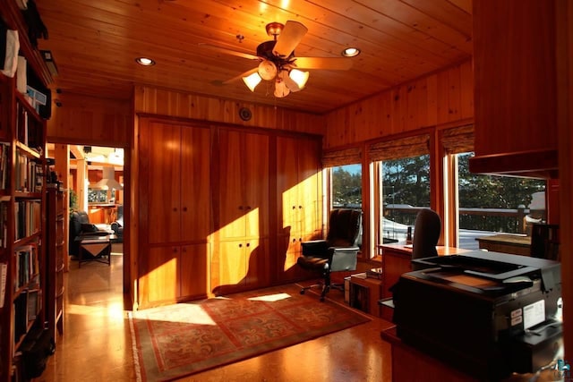 home office with wood walls, wooden ceiling, and ceiling fan