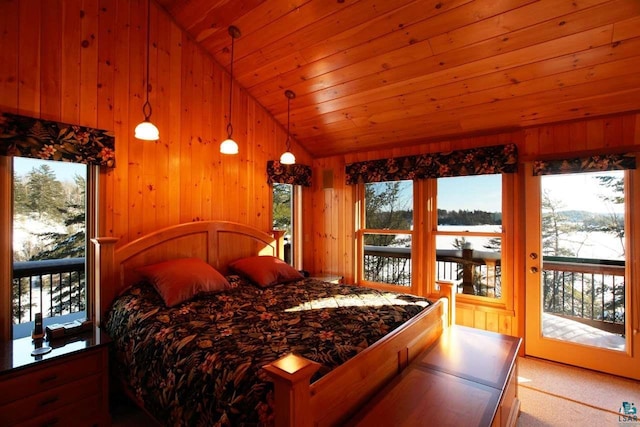 bedroom featuring wooden walls, vaulted ceiling, access to outside, and multiple windows