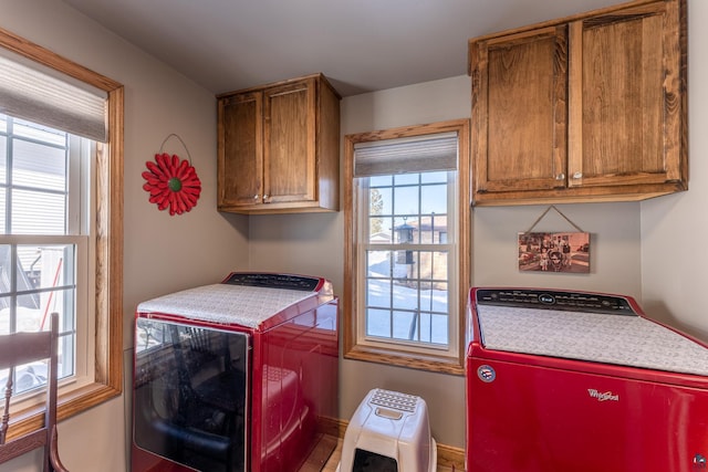 laundry area featuring cabinets, washer and dryer, and a wealth of natural light