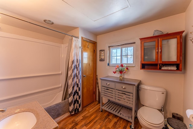 full bathroom featuring toilet, wood-type flooring, vanity, and shower / bath combo with shower curtain