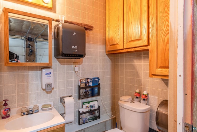 bathroom featuring tile walls, toilet, and vanity