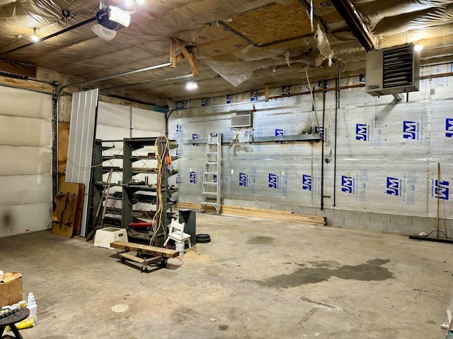 garage with a garage door opener and a wall mounted air conditioner