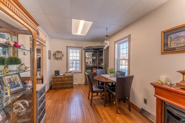 office area with a paneled ceiling, hardwood / wood-style floors, and plenty of natural light