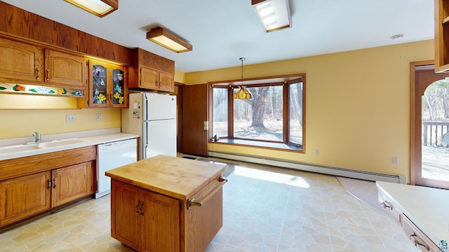 kitchen featuring plenty of natural light, white appliances, light tile floors, and a baseboard heating unit