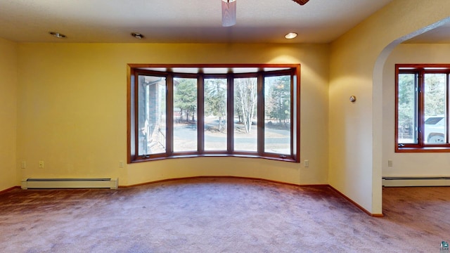 unfurnished room featuring ceiling fan, carpet, and baseboard heating