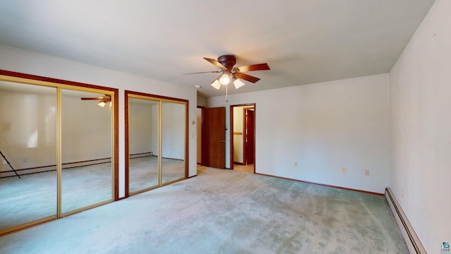 unfurnished bedroom featuring ceiling fan, two closets, light carpet, and a baseboard heating unit