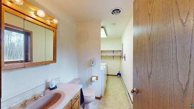 bathroom featuring washer / dryer, toilet, tile floors, and vanity