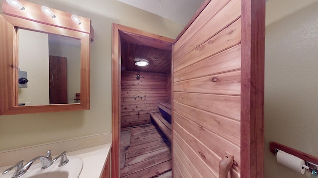 bathroom featuring wood walls and vanity