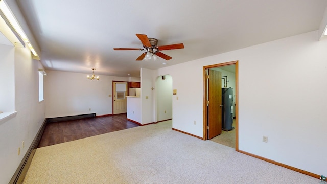 unfurnished room with ceiling fan with notable chandelier, dark wood-type flooring, and water heater