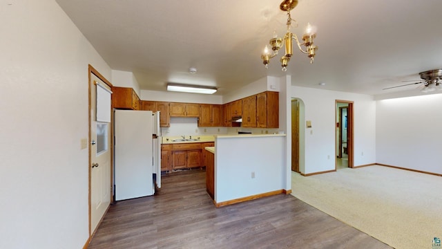 kitchen with ceiling fan with notable chandelier, white fridge, and dark carpet