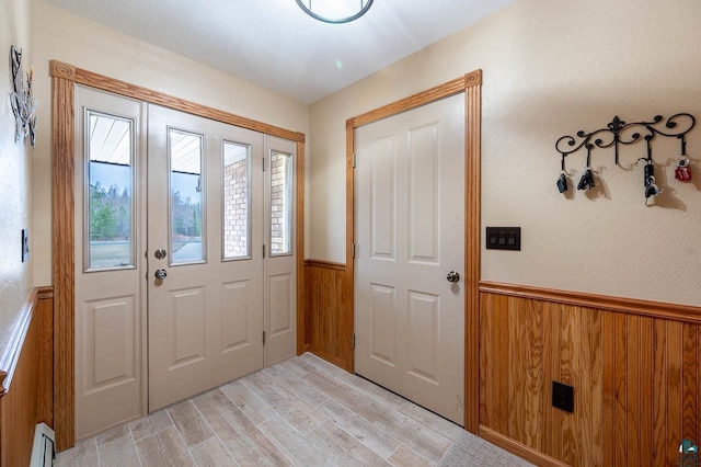 foyer with light hardwood / wood-style floors and baseboard heating