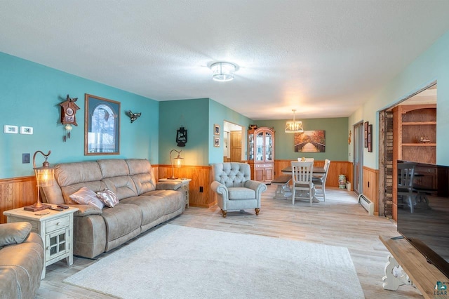 living room featuring a baseboard radiator, hardwood / wood-style flooring, and a textured ceiling