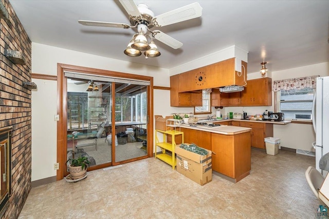 kitchen with brick wall, light tile flooring, a fireplace, kitchen peninsula, and ceiling fan