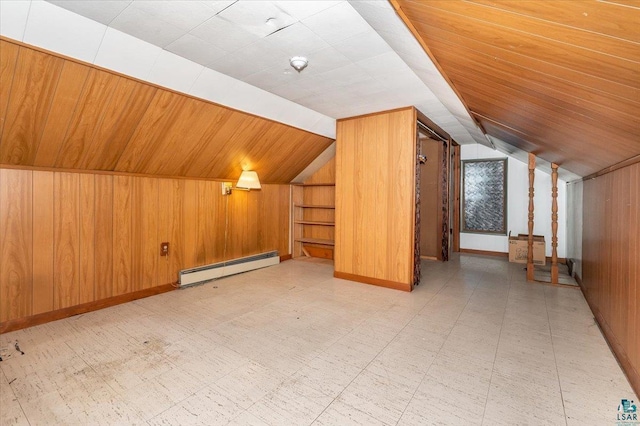 bonus room featuring a baseboard heating unit, vaulted ceiling, built in features, and wood walls