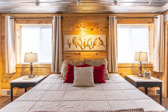 bedroom with wood walls, wood-type flooring, wooden ceiling, and multiple windows