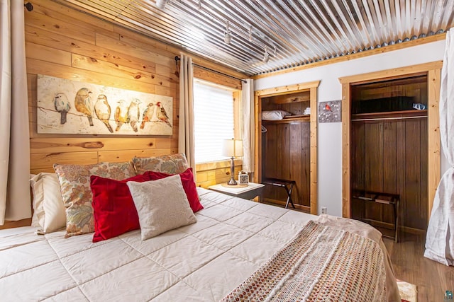 bedroom featuring wooden walls and wood-type flooring