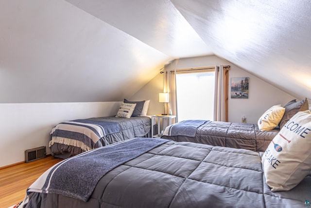 bedroom with wood-type flooring and lofted ceiling