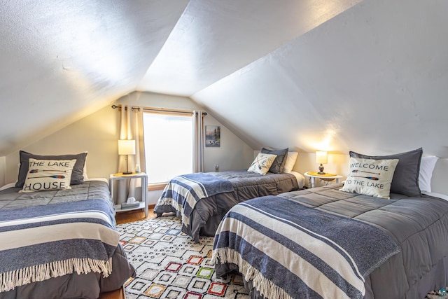 bedroom featuring light wood-type flooring and vaulted ceiling