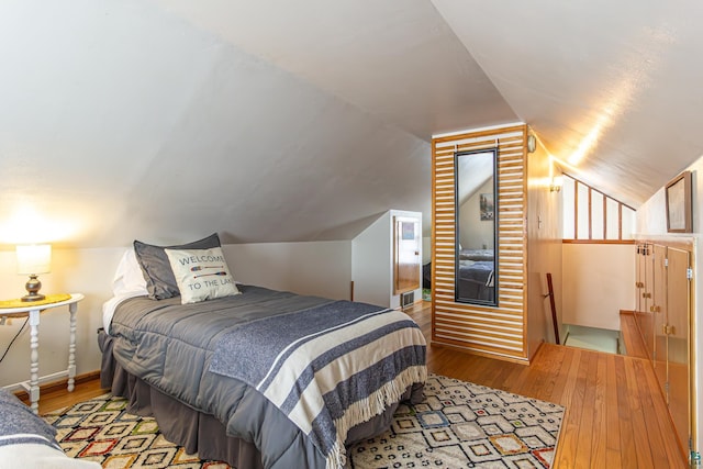 bedroom with light hardwood / wood-style floors and vaulted ceiling