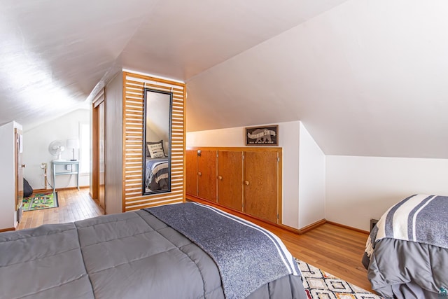 bedroom featuring light hardwood / wood-style floors and vaulted ceiling