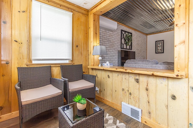 sitting room with wooden walls, hardwood / wood-style floors, and a wall mounted air conditioner