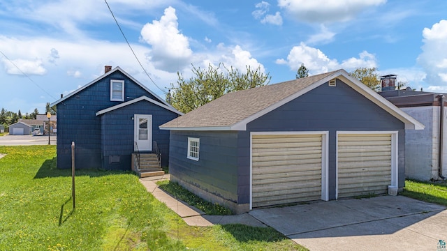 view of front of house featuring an outbuilding, a garage, and a front lawn