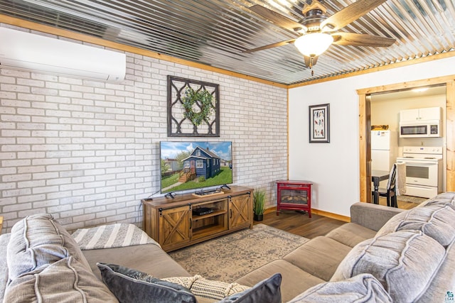 living room featuring an AC wall unit, ceiling fan, wood-type flooring, and brick wall