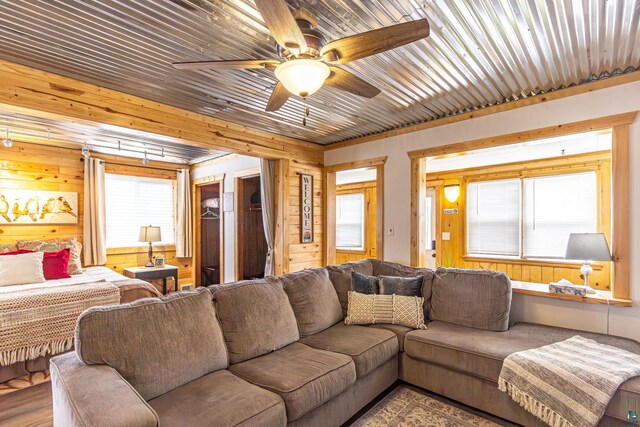 living room featuring ceiling fan and wooden walls