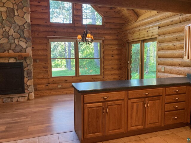 kitchen with rustic walls, kitchen peninsula, heating unit, a chandelier, and a fireplace