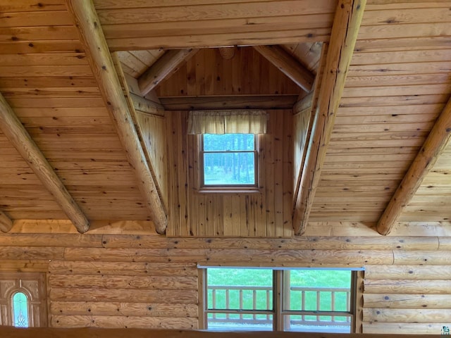 interior details featuring beamed ceiling, wood ceiling, and rustic walls