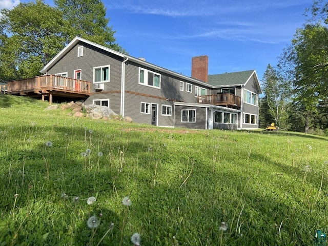 rear view of house featuring a yard and a deck