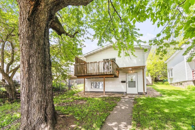 view of front of property featuring a front yard and a wooden deck