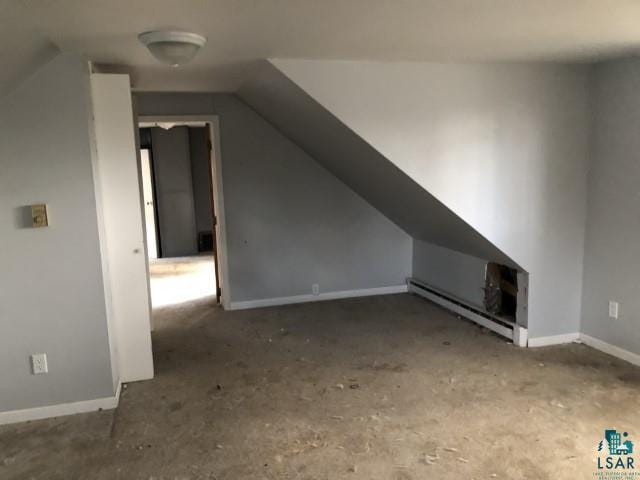 additional living space featuring lofted ceiling and baseboard heating