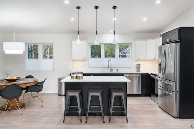 kitchen featuring appliances with stainless steel finishes, decorative light fixtures, plenty of natural light, and sink