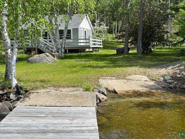 dock area with a yard and a deck with water view