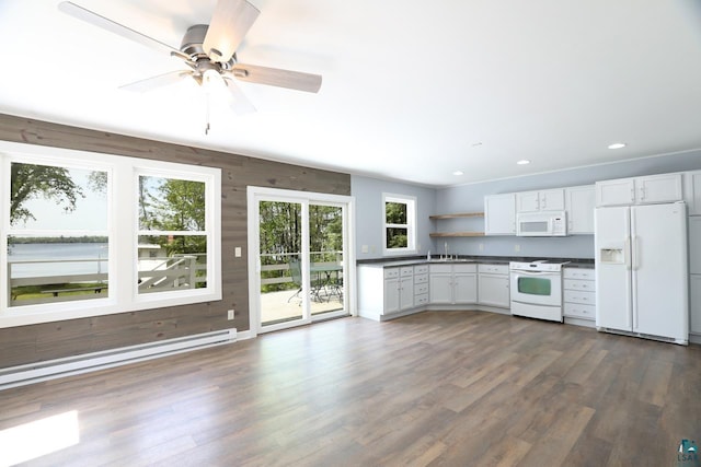 kitchen featuring dark hardwood / wood-style floors, ceiling fan, sink, wooden walls, and white appliances