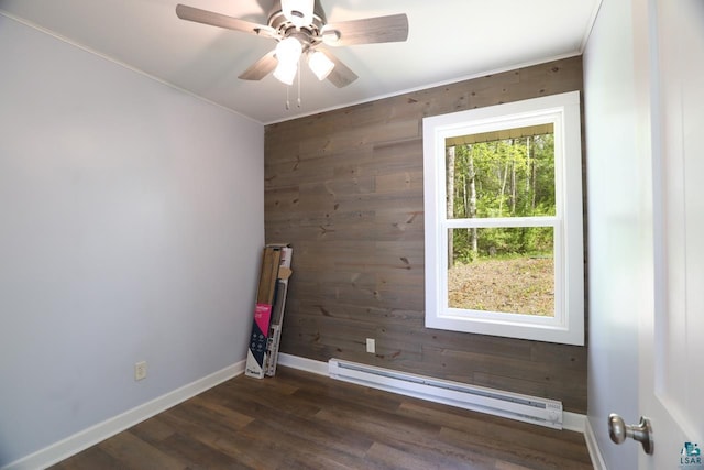 unfurnished room featuring dark hardwood / wood-style floors, ceiling fan, a healthy amount of sunlight, and baseboard heating